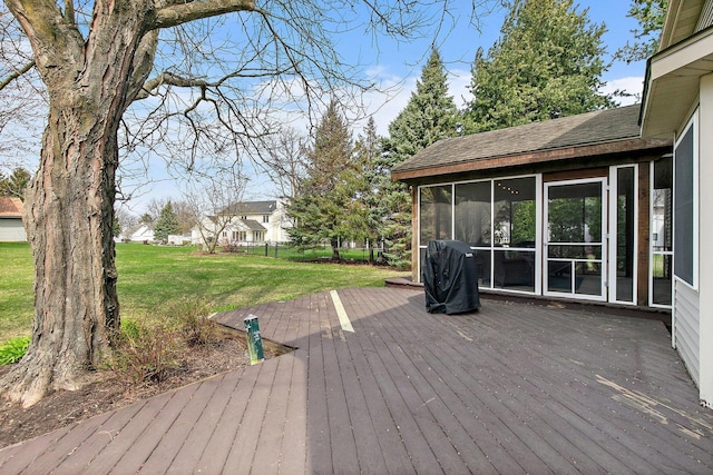 wooden deck with a yard and a sunroom