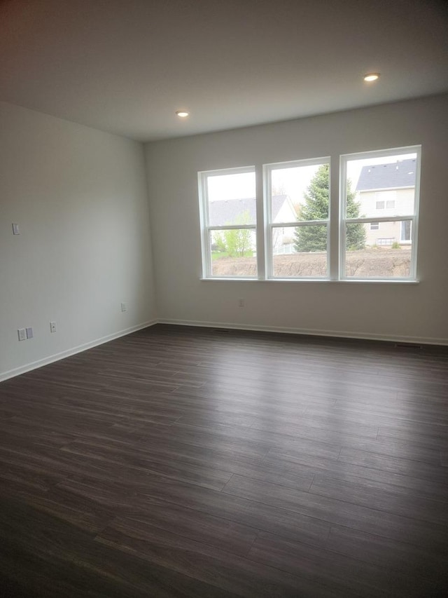unfurnished room with dark wood-style flooring, recessed lighting, and baseboards