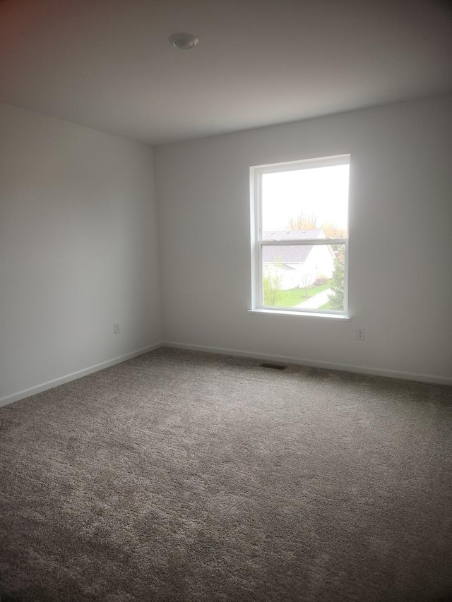 empty room featuring baseboards and carpet flooring