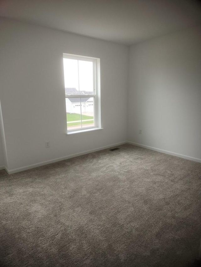 carpeted empty room with baseboards and visible vents