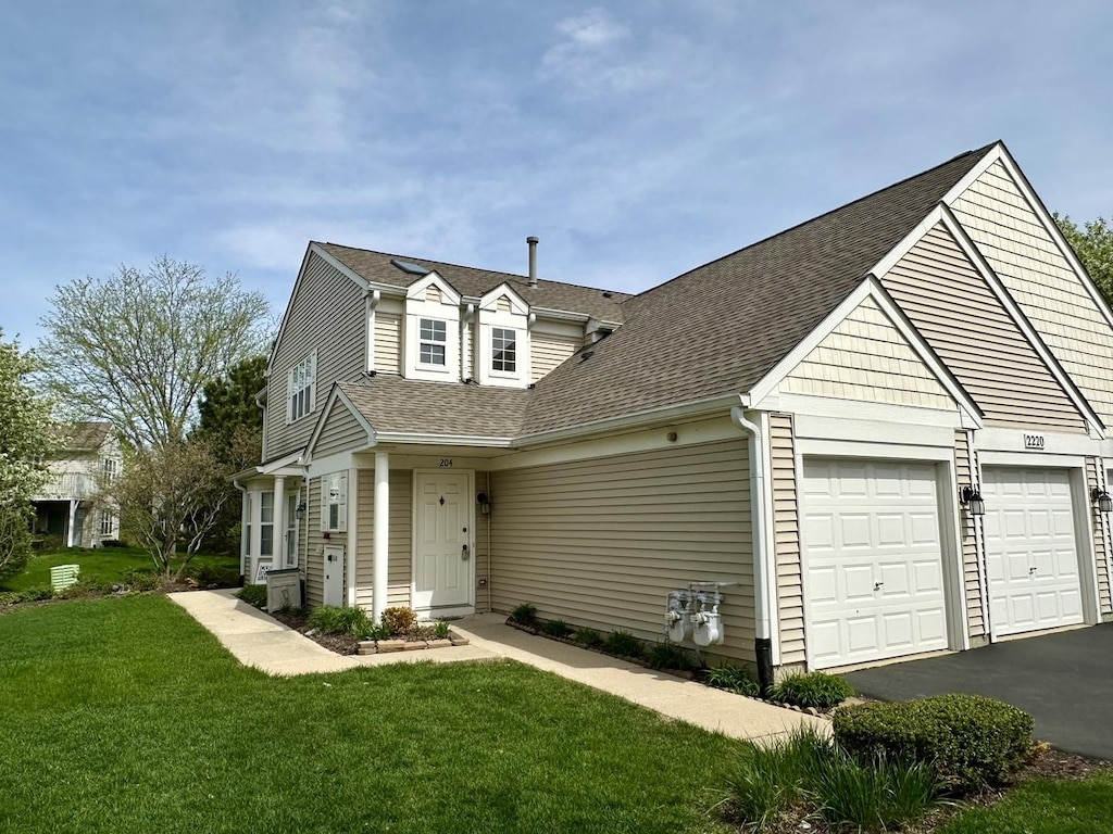 view of front facade with a garage, a front lawn, roof with shingles, and driveway