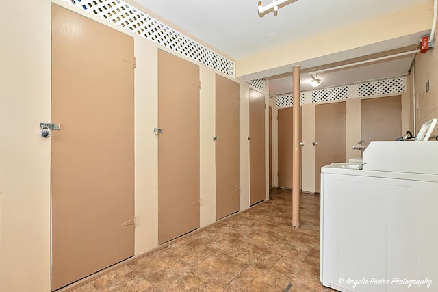 laundry area with laundry area, washer / dryer, and stone finish floor