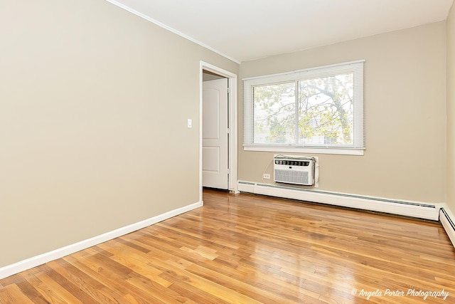 spare room featuring ornamental molding, light wood-style floors, baseboards, a baseboard heating unit, and a wall unit AC