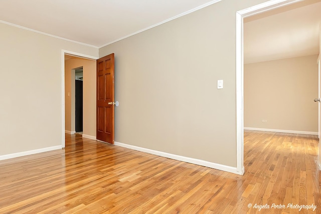unfurnished room with crown molding, baseboards, and light wood-style flooring