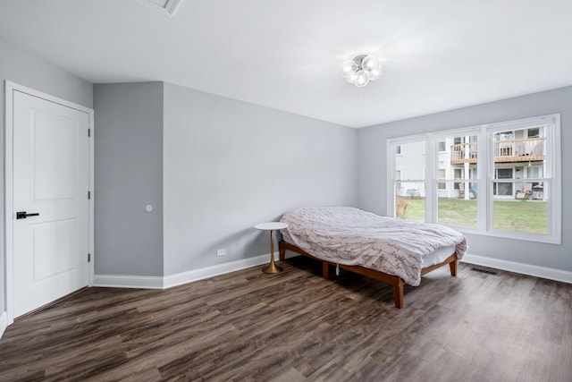 bedroom with visible vents, baseboards, and dark wood finished floors