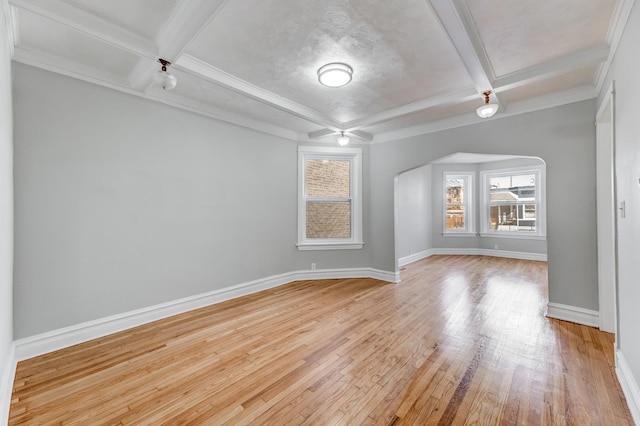 spare room featuring arched walkways, beam ceiling, light wood-type flooring, baseboards, and coffered ceiling