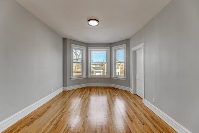 unfurnished room with light wood-style floors and baseboards