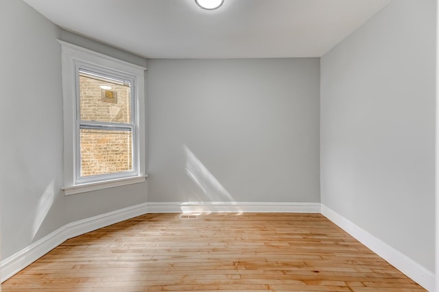 spare room featuring light wood-style floors and baseboards