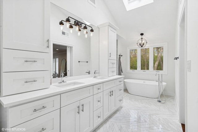 16 W Birchwood Ave, Hinsdale, IL 60521 - bathroom featuring a skylight, double vanity, a soaking tub, a towering ceiling, and a chandelier