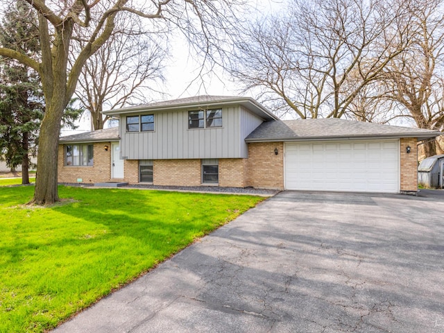 split level home with driveway, board and batten siding, brick siding, a front lawn, and a garage