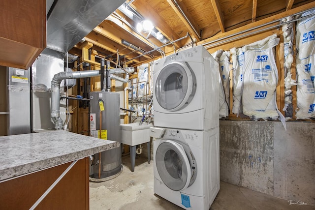 washroom featuring gas water heater, stacked washer / drying machine, and laundry area