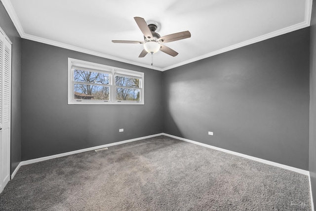carpeted spare room with baseboards, visible vents, a ceiling fan, and crown molding
