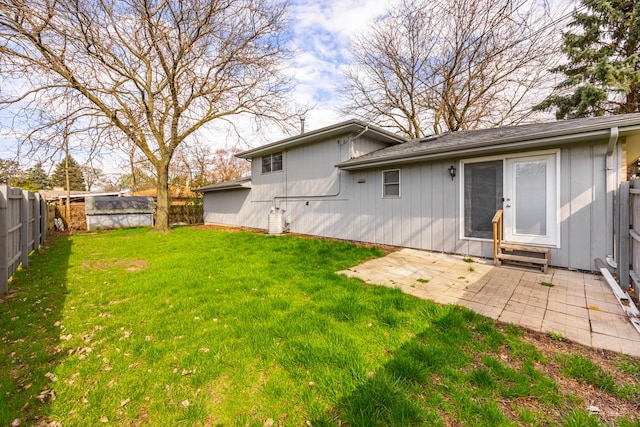 rear view of house featuring a patio, a fenced backyard, and a yard