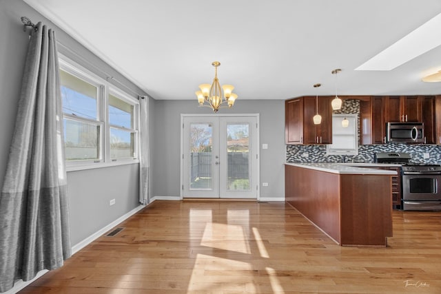 kitchen with light wood-type flooring, stainless steel appliances, and plenty of natural light