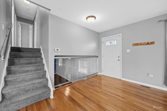 entryway featuring baseboards, visible vents, and wood finished floors