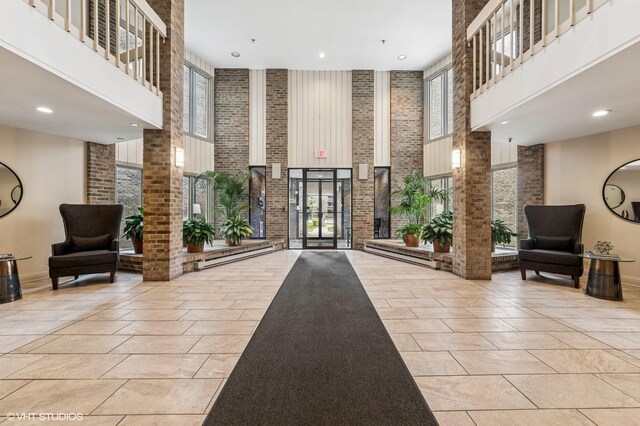 1220 Rudolph Rd Unit 5F, Northbrook, IL 60062 - common area with a towering ceiling, brick wall, and recessed lighting