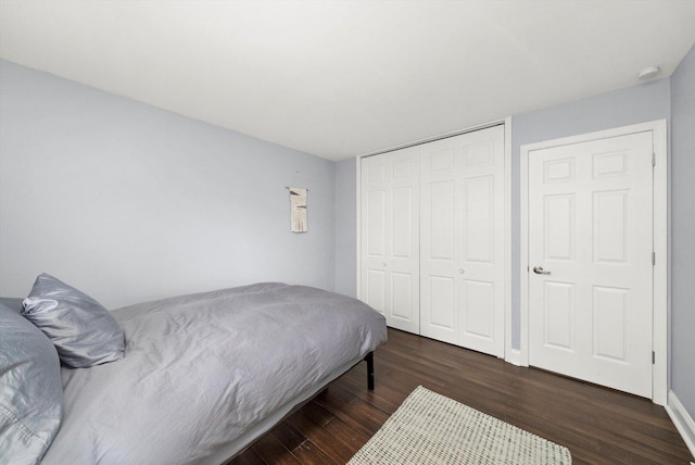 bedroom with baseboards, wood finished floors, and a closet