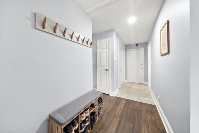 hallway featuring baseboards and wood finished floors