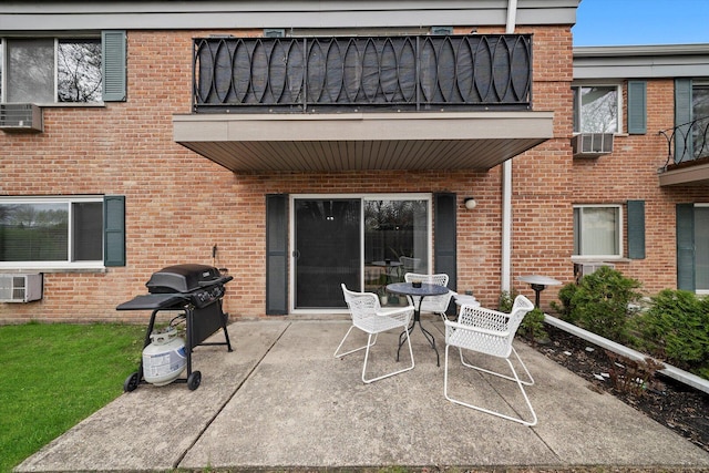 view of patio / terrace with cooling unit, a balcony, outdoor dining area, a wall mounted AC, and a grill