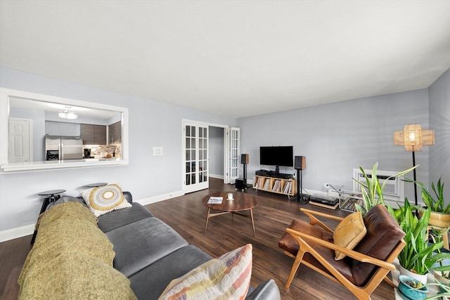 living area featuring baseboards, wood finished floors, and french doors