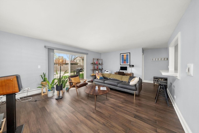 living area with baseboards, wood finished floors, and a baseboard heating unit