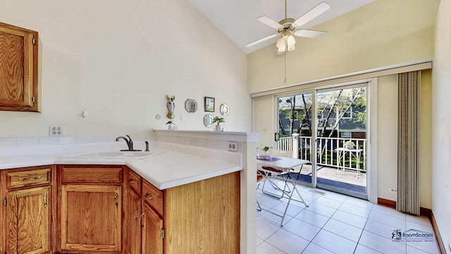 kitchen with light tile patterned floors, light countertops, a peninsula, a ceiling fan, and high vaulted ceiling