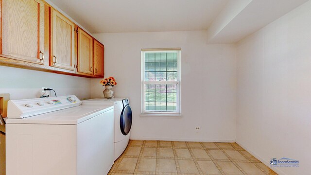 laundry area with washing machine and clothes dryer, cabinet space, light floors, and baseboards
