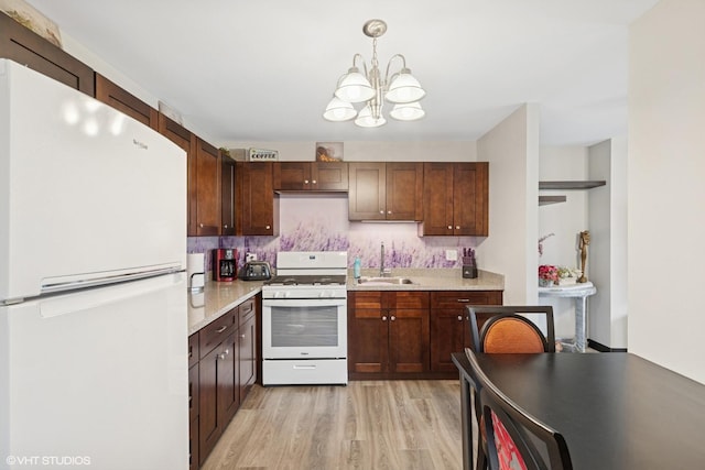4850 S Lake Park Ave Unit 510, Chicago, IL 60615 - kitchen featuring a sink, a chandelier, light wood-style floors, light countertops, and white appliances