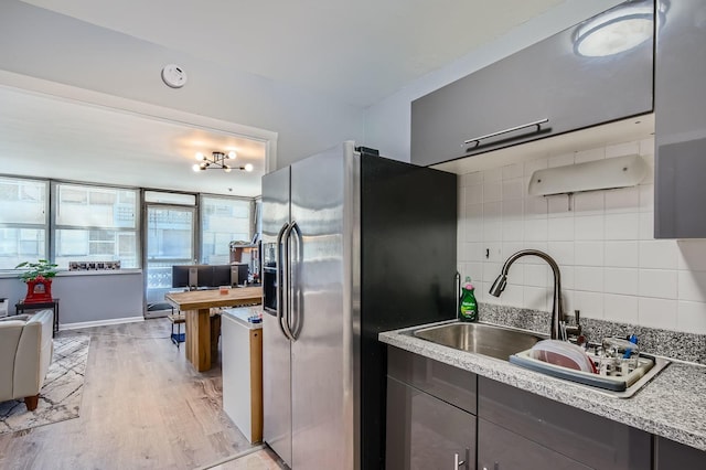 6301 N Sheridan Rd Unit 10F, Chicago, IL 60660 - kitchen featuring stainless steel refrigerator with ice dispenser, a sink, light wood-style floors, and decorative backsplash