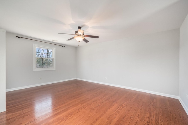 unfurnished room featuring wood finished floors, a ceiling fan, and baseboards