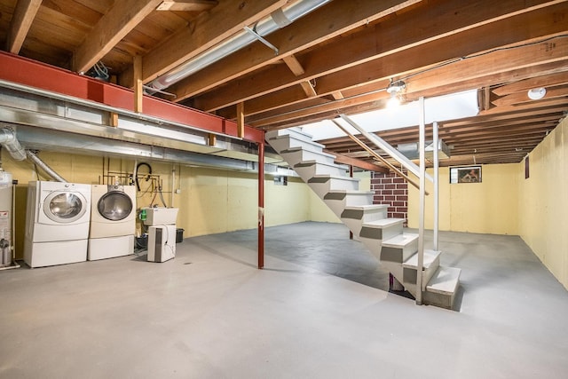 unfinished basement with water heater, stairs, and independent washer and dryer
