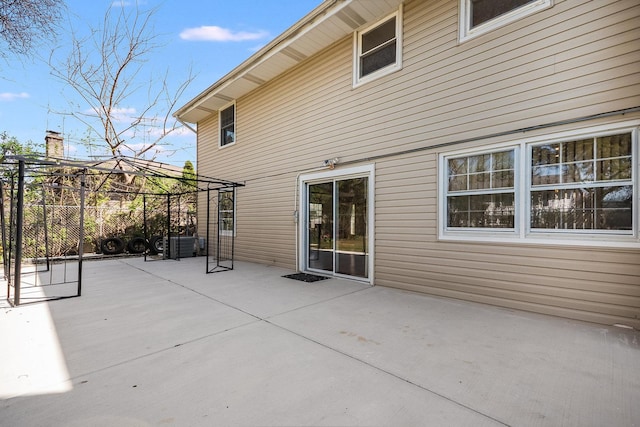 rear view of property featuring fence, a gazebo, and a patio area