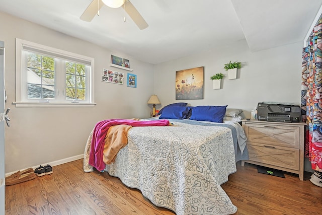 bedroom with wood finished floors, ceiling fan, and baseboards