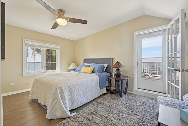 bedroom featuring a ceiling fan, lofted ceiling, wood finished floors, and baseboards