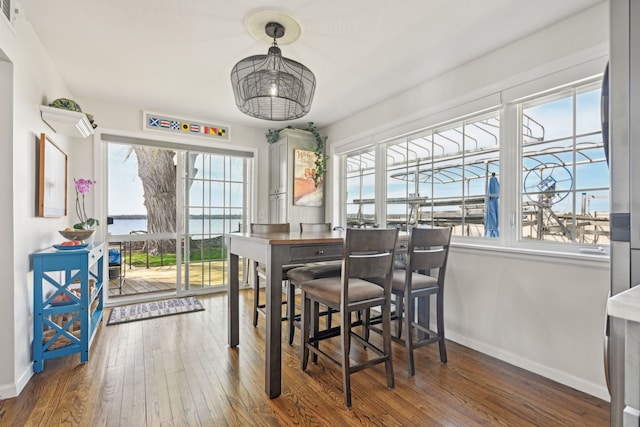 dining room featuring a wealth of natural light, wood-type flooring, and baseboards