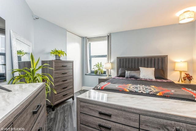 bedroom featuring dark wood-style floors and baseboards
