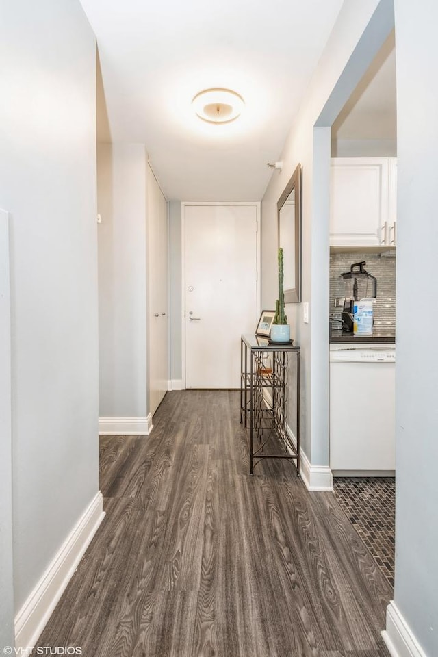 hallway with baseboards and dark wood-type flooring