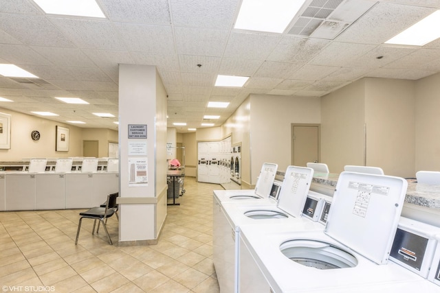 community laundry room with washing machine and dryer and light tile patterned flooring