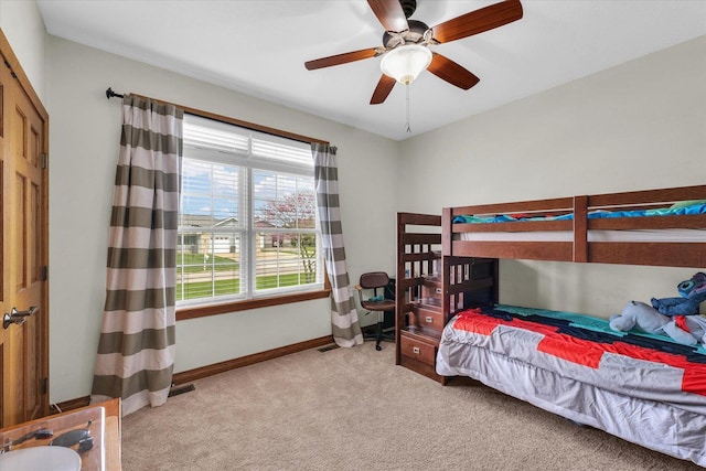 carpeted bedroom with baseboards and a ceiling fan