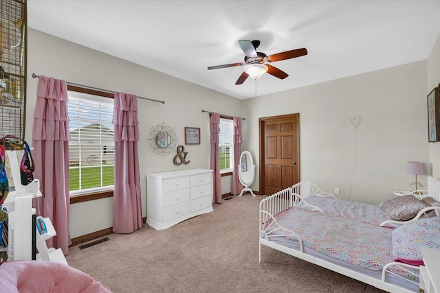 carpeted bedroom with baseboards, a ceiling fan, and visible vents