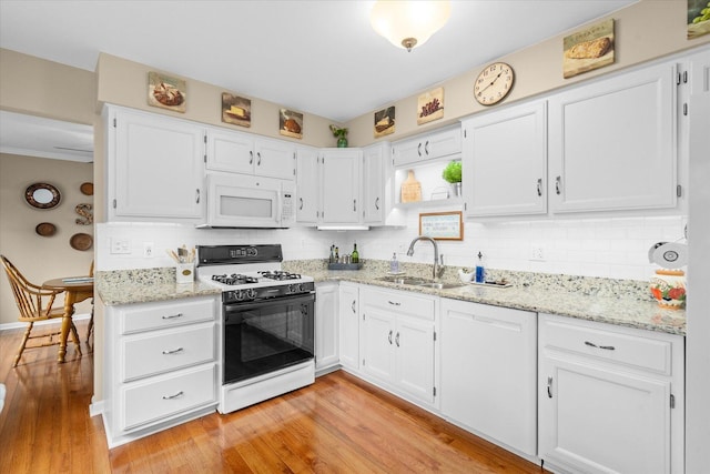1088 Alameda Dr, Aurora, IL 60506 - kitchen featuring white appliances, light wood-type flooring, white cabinetry, backsplash, and light stone countertops