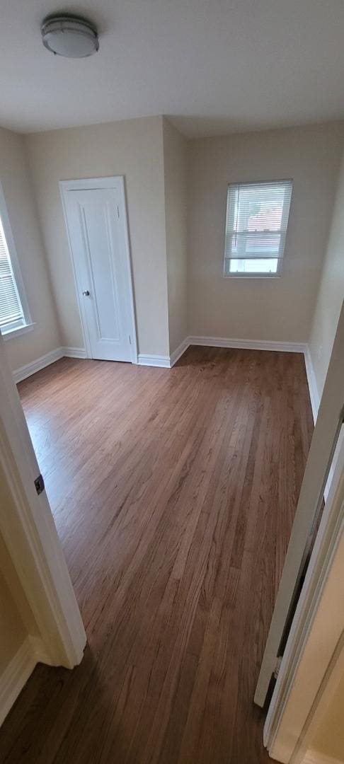 unfurnished room featuring wood finished floors and baseboards