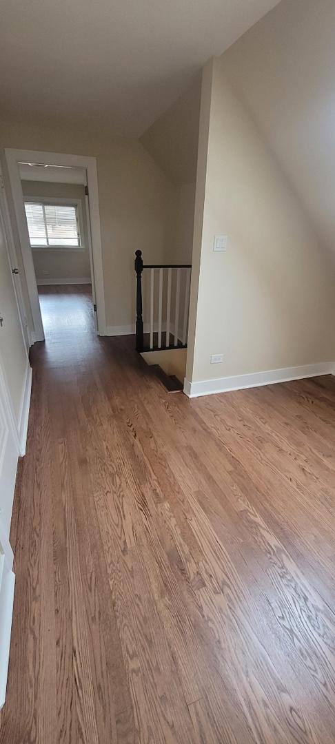 additional living space with lofted ceiling, wood finished floors, and baseboards