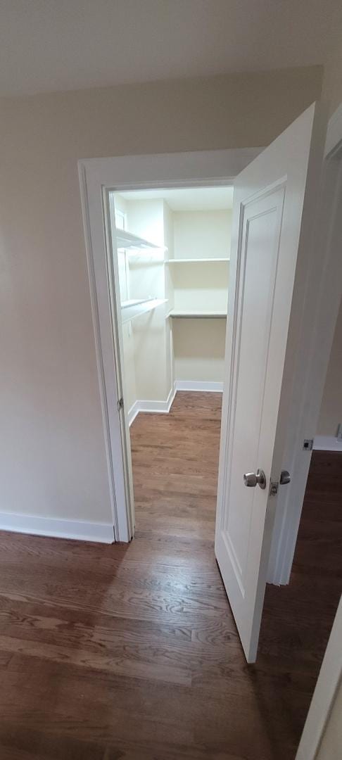 hall featuring baseboards and wood finished floors