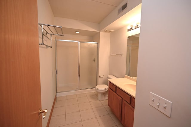 bathroom featuring tile patterned floors, a shower stall, toilet, and vanity