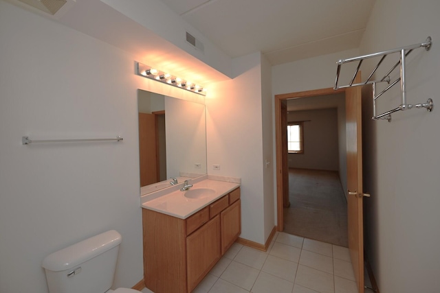 bathroom with tile patterned flooring, vanity, and toilet