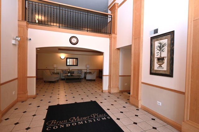community lobby featuring a high ceiling and a security system