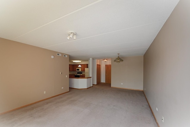unfurnished living room with light colored carpet and baseboards