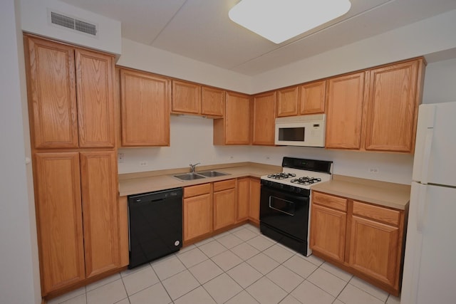 kitchen featuring white appliances, a sink, light countertops, and light tile patterned floors