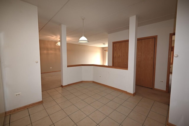 empty room featuring baseboards and light tile patterned flooring